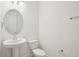 Cozy half bathroom with pedestal sink, oval mirror, and modern fixtures at 5099 Railroad Vine Aly, Winter Garden, FL 34787