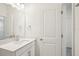 Bright bathroom featuring white walls, a large mirror above the sink, and white cabinets at 5099 Railroad Vine Aly, Winter Garden, FL 34787