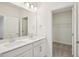 Bright bathroom featuring double sinks, white cabinets and a doorway to walk-in closet at 5099 Railroad Vine Aly, Winter Garden, FL 34787