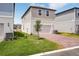Well-maintained two-story home displaying a brick driveway, garage, landscaped lawn, and attractive neutral siding at 5099 Railroad Vine Aly, Winter Garden, FL 34787