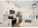 Contemporary kitchen with quartz countertops, stainless appliances, and white cabinets at 5099 Railroad Vine Aly, Winter Garden, FL 34787