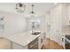 Spacious kitchen island with stainless dishwasher, sink, and pendant lighting above at 5099 Railroad Vine Aly, Winter Garden, FL 34787