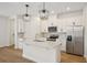 Modern kitchen with stainless steel appliances, white cabinets, and a center island at 5099 Railroad Vine Aly, Winter Garden, FL 34787