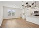 Open-concept living space with hardwood floors, modern lighting, and an adjacent kitchen area at 5099 Railroad Vine Aly, Winter Garden, FL 34787