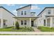 Charming two-story home featuring a quaint front porch, modern architectural details, and neatly manicured landscaping at 5106 Railroad Vine Aly, Winter Garden, FL 34787