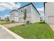 New two-story home with blue siding, two-car garage, and brick paver driveway at 5106 Railroad Vine Aly, Winter Garden, FL 34787