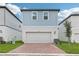 Charming two-story home featuring an attached garage, brick-paved driveway, and well-maintained lawn at 5106 Railroad Vine Aly, Winter Garden, FL 34787