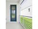 Inviting front entry features a modern railing system, a vibrant blue door, and a well-lit entry at 5106 Railroad Vine Aly, Winter Garden, FL 34787
