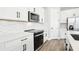 A close-up view of the stainless steel microwave and stove against a white backsplash and cabinets at 5106 Railroad Vine Aly, Winter Garden, FL 34787