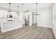 Open concept kitchen features white cabinetry, a center island, and stainless steel appliances with modern pendant lighting at 5106 Railroad Vine Aly, Winter Garden, FL 34787