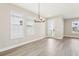 The living room has ample natural light from large windows with wood flooring at 5106 Railroad Vine Aly, Winter Garden, FL 34787