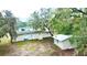 Aerial view showcasing the home and outbuilding surrounded by mature trees and lush landscape at 5390 E Hinson Ave, Haines City, FL 33844