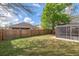 Fenced backyard with green grass and partial view of screen enclosed patio at 5580 Berwood Dr, Orlando, FL 32810