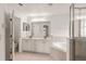 Bright bathroom with a double sink vanity, large mirror, soaking tub and separate glass shower at 5580 Berwood Dr, Orlando, FL 32810