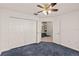 Bedroom with neutral walls, carpet flooring, closet, overhead ceiling fan and doorway view into hall at 5580 Berwood Dr, Orlando, FL 32810