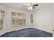 Bedroom with neutral walls, carpet flooring, large window, and overhead ceiling fan at 5580 Berwood Dr, Orlando, FL 32810