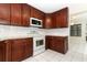 Cherry cabinets, white appliances, white tile backsplash, and white tile flooring at 559 Northbridge Dr, Altamonte Springs, FL 32714