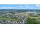 Expansive aerial view of the residential community with a pond, golf course, and lush greenery at 647 Ella Mae Dr, Davenport, FL 33897