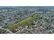 A wide aerial shot shows the neighborhood interspersed with a long green common area at 647 Ella Mae Dr, Davenport, FL 33897