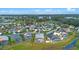 An aerial view of a home with a screened-in pool in a community with a green space and ponds at 647 Ella Mae Dr, Davenport, FL 33897