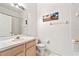 Bathroom with a shower, toilet, and a sink with cabinets, decorated with a painting at 647 Ella Mae Dr, Davenport, FL 33897