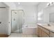 Bright bathroom featuring a glass-enclosed shower, separate tub, and ample counter space at 647 Ella Mae Dr, Davenport, FL 33897