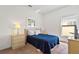 Bedroom showcasing the bed with blue comforter, carpeted floors, and a bright window at 647 Ella Mae Dr, Davenport, FL 33897