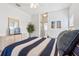 Spacious bedroom with carpet, a blue and white striped bedspread, and white furniture at 647 Ella Mae Dr, Davenport, FL 33897