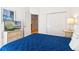 Bedroom featuring a bed with a blue comforter, nightstand, and a view of the closet at 647 Ella Mae Dr, Davenport, FL 33897