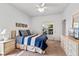 Bright bedroom featuring a blue and white striped bedspread and large windows at 647 Ella Mae Dr, Davenport, FL 33897