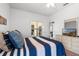 Well-lit bedroom featuring blue and white striped bedspread and access to an outdoor seating area at 647 Ella Mae Dr, Davenport, FL 33897