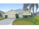 Charming single-story home with a well-manicured lawn and attached two-car garage at 647 Ella Mae Dr, Davenport, FL 33897