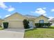 Inviting single-story home with a well-manicured lawn and attached two-car garage at 647 Ella Mae Dr, Davenport, FL 33897