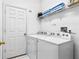 Laundry room with white washer and dryer, a shelf with towels, and a door at 647 Ella Mae Dr, Davenport, FL 33897