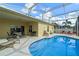 Inviting pool area with covered lanai, lounge chairs, and clear blue water at 647 Ella Mae Dr, Davenport, FL 33897