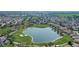 Stunning aerial view of a golf community with lush green fairways, a scenic lake, and beautiful homes at 7233 Se 171St Pond Ln, The Villages, FL 32162
