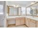 Bathroom with dual sinks, large mirrors, vanity, and linen closet at 7233 Se 171St Pond Ln, The Villages, FL 32162