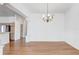 Open dining room featuring gleaming hardwood floors, a chandelier, and a large arched entry at 7233 Se 171St Pond Ln, The Villages, FL 32162