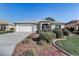 Charming home featuring a well-manicured front yard with beautiful landscaping and an attached two-car garage at 7233 Se 171St Pond Ln, The Villages, FL 32162