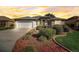 Charming home featuring a well-manicured front yard with beautiful landscaping and an attached two-car garage at 7233 Se 171St Pond Ln, The Villages, FL 32162