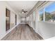 Bright lanai with wood-look flooring, ceiling fan, sliding glass doors, and exterior view at 7233 Se 171St Pond Ln, The Villages, FL 32162