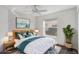 This bedroom features white walls, a fan, a wooden headboard bed, and a large window overlooking the yard at 7233 Se 171St Pond Ln, The Villages, FL 32162