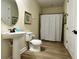Well-lit bathroom with a pedestal sink, modern fixtures, and a shower with decorative curtain at 7668 Wilmington Loop, Kissimmee, FL 34747