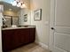 Bathroom featuring a dark wood vanity, tile floor, and a large mirror at 7668 Wilmington Loop, Kissimmee, FL 34747