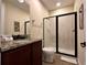 Compact bathroom featuring a glass shower, vanity, and light tile at 7668 Wilmington Loop, Kissimmee, FL 34747
