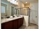 Granite countertop vanity and glass shower enclosure in renovated bathroom at 7668 Wilmington Loop, Kissimmee, FL 34747
