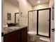 Bathroom featuring a granite countertop vanity and glass shower with a black frame at 7668 Wilmington Loop, Kissimmee, FL 34747
