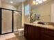 Bathroom featuring a glass shower and granite-topped vanity at 7668 Wilmington Loop, Kissimmee, FL 34747
