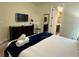 Bedroom with a king-size bed and ensuite bathroom, featuring a TV and dark wood furniture at 7668 Wilmington Loop, Kissimmee, FL 34747