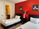 Charming bedroom with twin beds, a bold red accent wall, and themed decor at 7668 Wilmington Loop, Kissimmee, FL 34747